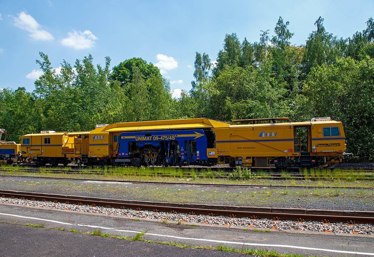 Am 11.06.2021 abgestellt auf dem Gleis 4 im Bahnhof Herdorf: Die Plasser & Theurer Universalstopfmaschine UNIMAT 09-475/4S (Kombinierte Gleis- und Weichenstopfmaschine), Schweres Nebenfahrzeug Nr. D-DGU 99 80 9424 001-2 und dahinter die Plasser & Theurer Schotterverteil- und Planiermaschine SSP 110 SW, Schweres Nebenfahrzeug Nr. D-DGU 99 80 9425 068-0, ex 97 16 46 516 18-9 D-DGU (ex Hering Gleisbau, ex Volker-Rail). Beide Maschinen gehören der der DGU - Deutsche Gleisbau Union aus Koblenz.