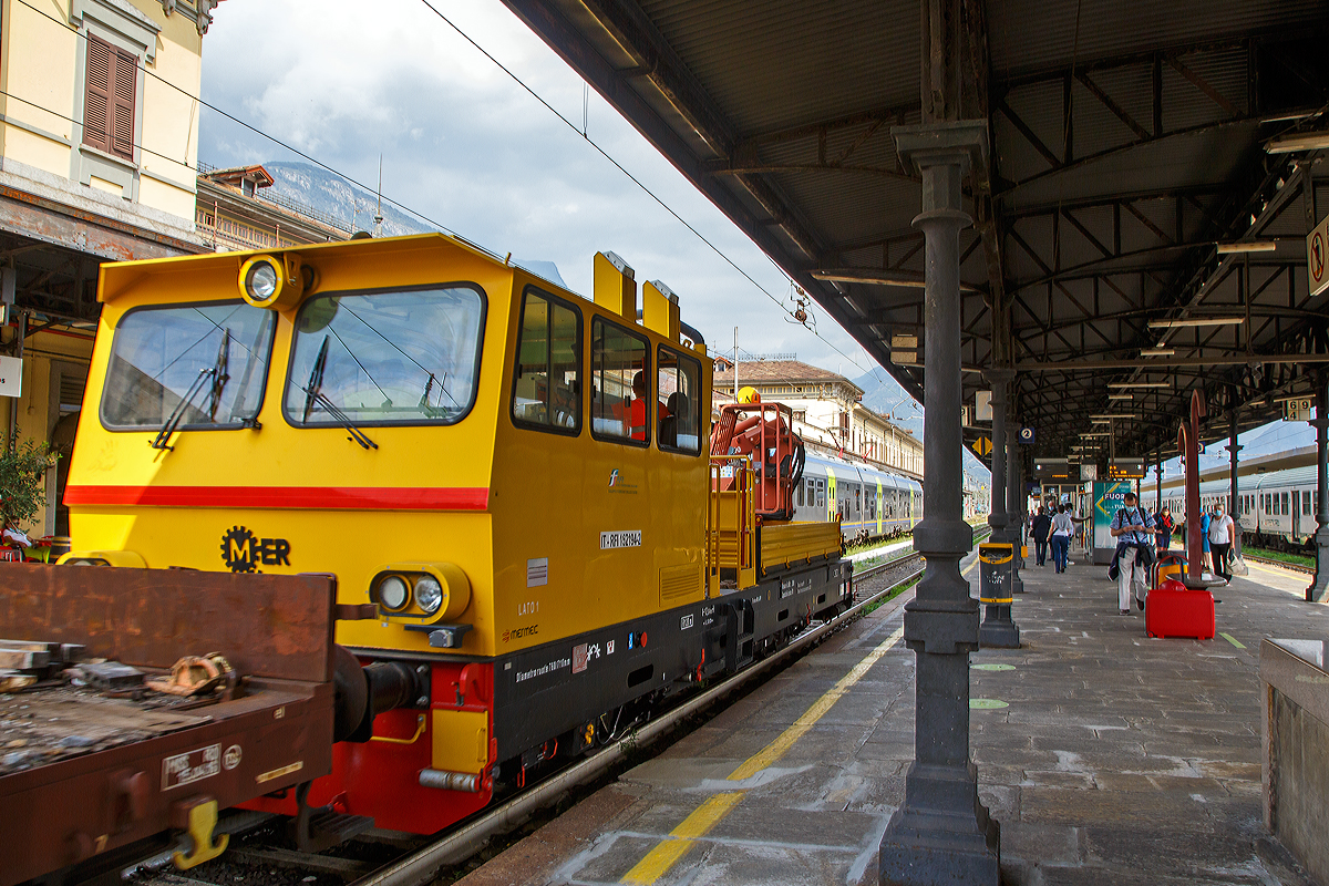 Das Italienische MerMec Gleisarbeitsfahrzeug (Autocarrello) IT-RFI 152 194-2 der RFI (Rete Ferroviaria Italiana) fhrt am 08.09.2021 mit einem vierachsigen Flachwagen durch den Bahnhof Domodossola in Richtung Norden.