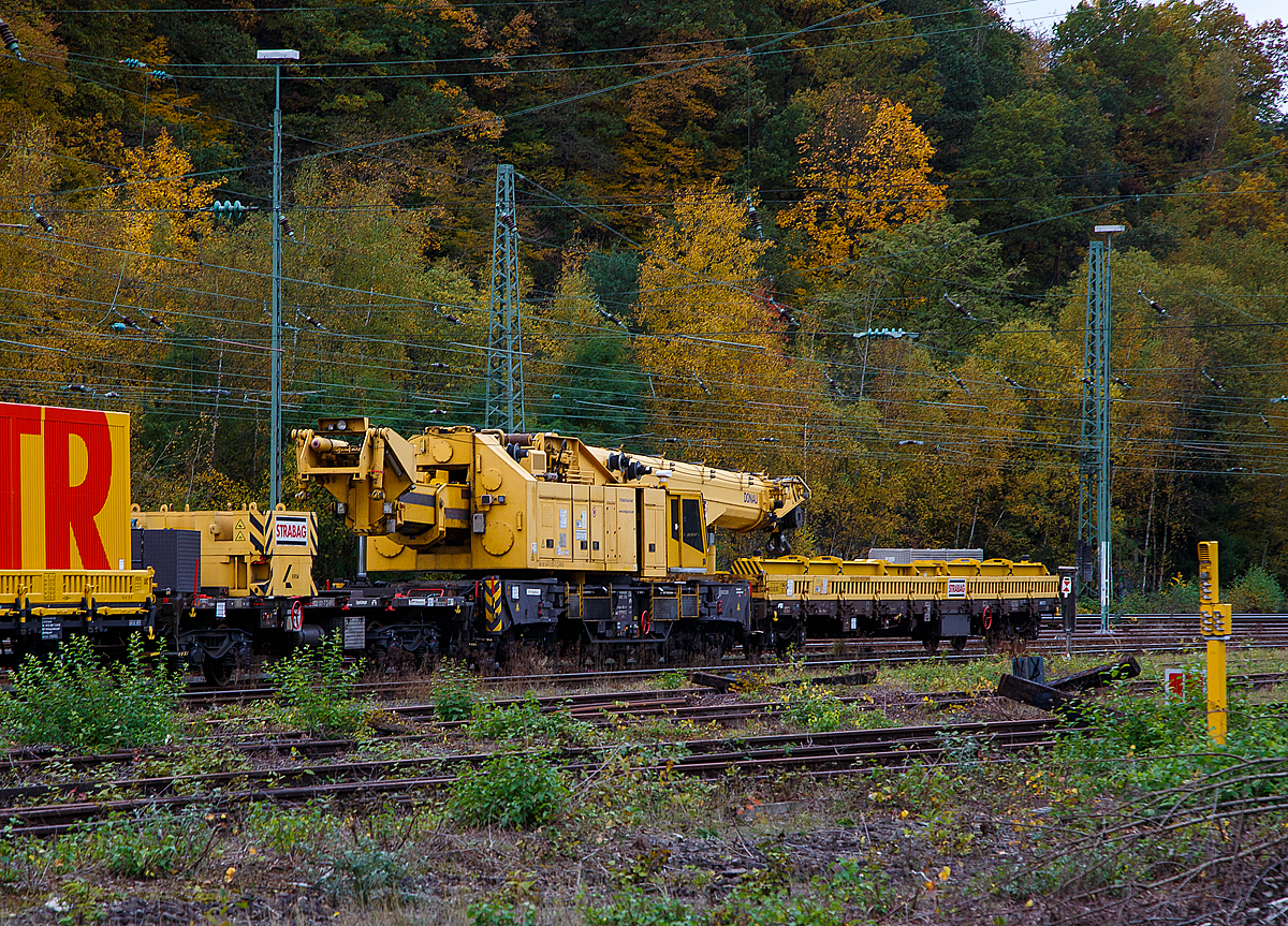 Der 150 t Kirow Gleisbaukran KRC 1200+ (ein Kirow MULTI TASKER KRC 1200+,  99 80 9419 005-0 D-BRS  „DONAU“  (ex 97 82 55 508 17-5) der STRABAG Rail GmbH ist am 27.10.2021 in Transportstellung in Betzdorf/Sieg abgestellt.  BRS steht für Strabag BMTI Rail Service GmbH (Berlin). 

Der Kranzug besteht im Einzelnen von rechts nach links) aus: 
• 4-achsiger Schutzwagen auslegerseitig, 99 80 9320 005-8 D-BRS, beladen u.a. mit den zugeh. Traversen, hier in der Transportstellung wird der Kranausleger hydraulisch auf dem Schutzwagen abgestützt. Durch die Abstützung wird die Achslast und folglich die Streckenlast (Meterlast) vom Kran auf max. 7,4 t/m reduziert.
• Der eigentliche Gleis- und Weichenbaukran Kirow MULTI TASKER KRC 1200+ „Donau“.
• Der vierachsige Gegenlastwagen 99 80 9320 001-7 D-BRS (ein Drehgestell-Flachwagen). Auf dem Wagen liegen die Gegengewichte (Gegenlast) zum Kran, zudem wird auch hier in der Transportstellung das Gegenlast-Teleskop hydraulisch auf dem Gegenlastwagen abgestützt. Durch die Abstützung wird die Achslast und folglich die Streckenlast (Meterlast) vom Kran auf max. 7,4 t/m reduziert. Im Kranbetrieb können die am Wagen liegende Gegengewichte vom Gegenlast-Teleskop automatisiert aufgenommen werden. Zudem kann eine Lastablegung (Gegengewicht) auf Gegengewichtswagen im Kranbetrieb für eine Achslastreduzierung erfolgen.
• Der Zweiachsige Flachwagen mit Seiten-, Stirnwandklappen und Drehrungen, 23 62 3329 003-0 CG-BRS der Gattung Kgs-z, (eingestellt in Montenegro), beladen mit einem 20“-Werstatt-Container und einem ELCOS-Stromaggregat.

Der Kran wurde 2009 von Kirow Ardelt AG in Leipzig unter der Fabriknummer 152500 gebaut. Er wird als Schweres Nebenfahrzeug Nr.: 99 80 9419 005-0 (ehemals 97 82 55 508 17-5) geführt und hat die EBA-Nr. EBA 09C02A001. Der Gegenlastwagen 2009 unter der Fabriknummer 152600 gebaut.

Der Kran gehört zu einer der größten Gleisbaukranklassen, hat aber in der Transportstellung durch die Abstützungen auf den Kranauslegerschutzwagen und den Gegenlastwagen geringere Streckenlast (Meterlast) von max. 7,4 t/m, als seine kleineren Brüder.
Das Gegengewicht ist ausfahrbar und separat bis ± 30º  schwenkbar, sodass ein Einschwenken in den Bereich des Nachbargleises vermieden und ein profilfreies Arbeiten ermöglicht wird.

TECHNISCHE DATEN von dem Kran:
Spurweite: 1.435 mm
Eigengewicht  (in Transportstellung) : 111,0 t 
Länge über Puffer:  15.000 mm  (+13.000 mm Gegenlastwagen,+ 20.000 mm Ausleger-Schutzwagen)
Motorleistung:  254 kW bei 2.200 U/min
max. Geschwindigkeit im Zugverband: 100 km/h
max. Geschwindigkeit im Eigenantrieb: 19 km/h
Achsanzahl:  8 (in 4 Drehgestelle bzw. 2 Doppeldrehgestelle)
Drehzapfenabstand: 10.000 mm
Drehzapfenabstand im Drehgestell 1 und 2: 2.300 mm
Achsabstand in den Einzeldrehgestellen: 1.100mm
Ergebene Achsabstände in m: 1,1 / 1,2 / 1,1/ 6,6 / 1,1 / 1,2 / 1,1
Achsfolge: 1'A'1A'A1'A1'
Radsatzlast Transport Kran: max. 13,8 t
Radsatzlast Gegengewichtswagen:  max. 20,0 t
Meterlast (Streckenlast) in Transportstellung Kran max.: 7,4 t/m
Höhe in Transportstellung:  4.300 mm
Breite in Transportstellung:  3.100 mm
max. Ausladung vor Puffer:  21.000 mm
max. Traglast bei max. Ausladung:  40 t
Größte mögliche Traglast: 150 t (abgestützt)  / 120t (freistehend)
max. Hakenhöhe:  24.000 mm
hintere Ausladung (Gegenwicht):  7,9 m–13,5 m
Zul. Anhängelast: 160 t
Kleinster befahrbarer Radius: 80 m (120 m im Schleppbetrieb)

Besondere Ausstattung:
Überhöhenausgleich 180 mm
Schwenkradius ± 360º
Abstützung teleskopierbar bis 8 m Abstützbasis
profilfreies Arbeiten bis ± 30º