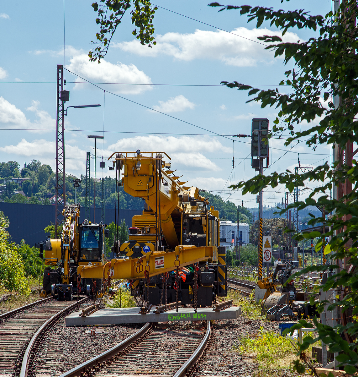 Der 50 t GOTTWALD Gleisbauschienenkran GS 50.09 T, Schweres Nebenfahrzeug Nr. 99 50 9219 028-9 CH-BRS „Werner“ der BMTI Rail Service GmbH (Servicebetrieb der STRABAG SE), ex VTmaas 99 85 92 19 028-9 VANOMAG AG Kran VIII, ex VTmaas 80 85 94 81 407-7, ist am 30.07.2021 im Bahnhof Siegen-Weidenau im Einsatz. Nun ist aber erst mal Mittagspause.

Der Kran wurde 2002 von Gottwald in Düsseldorf gebaut.

TECHNISCHE DATEN:
Spurweite: 1.435 mm
Anzahl der Achsen: 6 (in 2 Drehgestellen)
Länger über Puffer: 12.000 mm (ohne Kranausleger)
Drehzapfenabstand: 7.000 mm
Achsabstand im Drehgestell : 1.500 mm
Raddurchmesser: 920 mm (neu) 
Breite in Transportstellung: 3.100 mm
Höhe in Transportstellung: 4.200 mm
Eigengewicht: 116 t in Transportstellung (Gegengewicht abgelegt)
Traglast:  50.000 kg bei 3,0 m Ausladung vor Puffer 
  18.300 kg bei 12,5 m Ausladung vor Puffer
Kleinster befahrbarer Radius: 90 m 
max. Geschwindigkeit im Zugverband: 100 km/h
max. Geschwindigkeit im Eigenantrieb: 25 km/h
Bremse: KE-GP mZ (D)