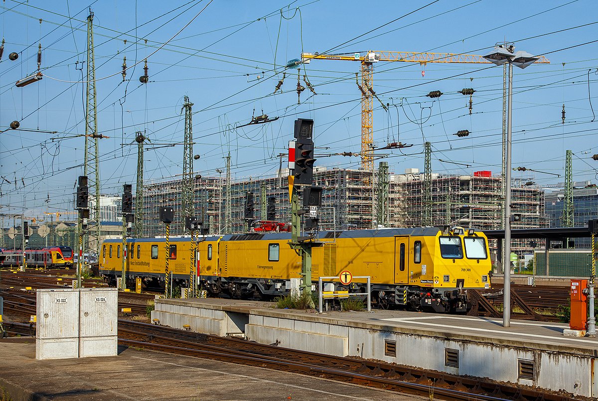 Der Plasser & Theurer Schienenprüfzug (der Bauart SPZ 3) 719 301 / 720 301 (99 80 9160 004-4-DB / 99 80 9360 006-7 D-DB) der DB Netz AG steht am 04.06.2019 im beim Hbf Frankfurt am Main. Da mein Zug bald fuhr reichte es nur über die Bahnsteige hinweg, bzw. noch ein Bild aus dem Zug.

Der Schienenprüfzug wurde 2015 von Plasser & Theurer in Linz (A) unter der Fabriknummer 6003 (SPZ-STW) und  6047 (SPZ-ATW) gebaut.

Um Schäden am Oberbau frühzeitig zu erkennen, setzt die Deutsche Bahn AG verschiedene Prüfzüge der Baureihen 719 und 720 ein. Mittels zweier zerstörungsfreier Prüfverfahren werden die Schienen auf Schädigungen untersucht. Bei der Ultraschallprüfung können Materialfehler durch Materialermüdung innerhalb der Schiene bis zum Schienenfuß erkannt werden. Mit der Wirbelstromprüfung wird der Schienenkopf geprüft. 

Die Schienenprüfzüge der BR 719.3/720.3 sind die dritte Messtriebwagengeneration und wurden in modularisierter Bauweise von Plasser & Theurer in Linz (A) gebaut. Sie basiert auf einer ein- und zweiteiligen Messwagenfamilie, die Ende 2012 von der DB Netz AG bestellt wurde. Die Schienenprüfzüge sind zweiteilig ausgeführt und bestehen aus einem allachsgetriebenen Trieb- (ATW) und einem Steuerwagen (STW). Beide Wagen sind jeweils 23 Meter lang. Der ATW hat ein Eigengewicht von 81 t, der STW 67 t. Der Triebzug hat eine Höchstgeschwindigkeit von 140 km/h. Der Einsatz auf Steilstrecken der DB Netz AG ist bis 55 ‰ genehmigt.

Unter dem Bodenrahmen des Steuerwagens sind, zwischen den beiden Drehgestellen, ein absenkbarer Messwagen und zwei Wasserbehälter für die ZfP-Sensorik aufgehängt. Auf dem Dach des Triebwagens sitzt ein Messstromabnehmer. Als Antrieb dienen zwei Deutz-Dieselmotoren. Im hinteren Teil des Triebwagens gibt es eine klimatisierte Küche mit Mikrowelle, Herd, Spüle, Tisch und Sitzecke mit Wifi sowie eine Toilette. Im Steuerwagen sind neben dem Beobachtungsstand mit neun Monitoren eine Werkstatt mit Ersatzteillager und Kalibriergeräten, Schaltschränke mit Messtechnik, vier Schlafabteile und der Führerstand 1 untergebracht. Die Ultraschall- und Wirbelstrommesstechnik wurde von der Firma PLR Magdeburg geliefert.