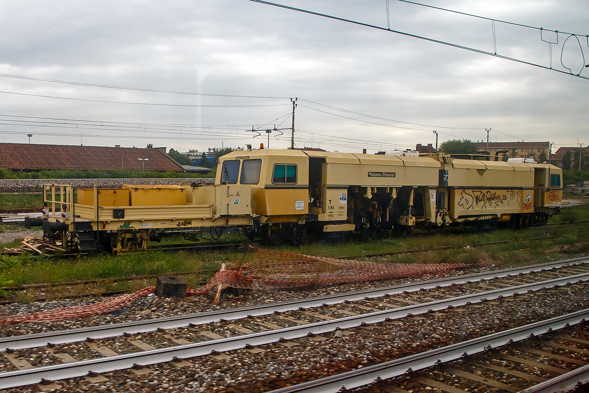 Eine Plasser & Theurer 08-275 Unimat 3S Universal-Gleisstopfmaschine der RFI (Rete Ferroviaria Italiana) ist am 14.09.2017 bei Monza abgestellt (aufgenommen aus einem Zug heraus).