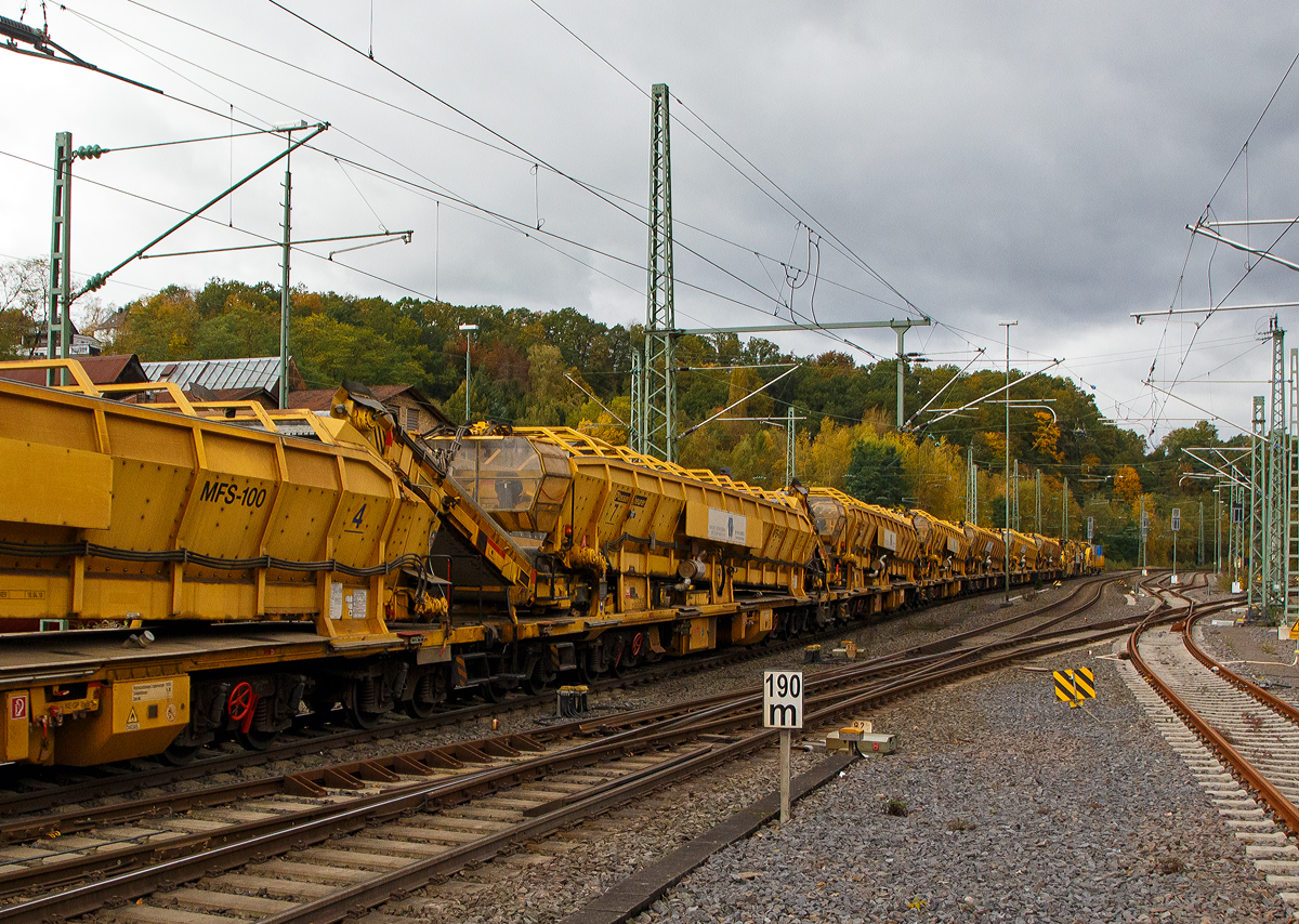 Plasser & Theurer Materialförder- und Siloeinheit MFS 100-S, Nr. 7 der MGW Gleis- und Weichenbau-Gesellschaft mbH & Co. KG (Berlin), Schweres Nebenfahrzeug Nr. 99 80 9552 511-4 D-MGW (ex 99 80 9552 511-4 D-BRS – STRABAG Nr. 15), am 22.10.2021 im Zugverband in Betzdorf (Sieg) bei einer Zugdurchfahrt (dahinter noch weitere).

Die Einheit wurde 2010 von Plasser & Theurer unter der Fabriknummer 5434 gebaut.

Die MFS 100 und dienen zum Transport von Schotter, Abraum und Pufferspeicher bei der Bettungsreinigung bzw. Planumsverbesserung. Hauptvorteil ist der kontinuierliche Förder-, Speicher- und Entladevorgang. Eine Zusammenstellung von beliebig vielen MFS-Wagen zu einem Zug mit jeweils gewünschter Speicherkapazität ist möglich. Der Füllvorgang beginnt beim vordersten Wagen (in Arbeitsrichtung), die folgenden Wagen dienen als Förderstraße.
Eine gleichzeitige Entleerung aller MFS-Wagen durch Ausschwenken der Entladebänder ist möglich, zudem eine dosierte Entladung zum Nachbargleis (Baugleis). Bei diesem Typ  MSF 100 „S“ (mit Einschotterungssystem) ist auch eine Endladung nach unten ins Gleis möglich