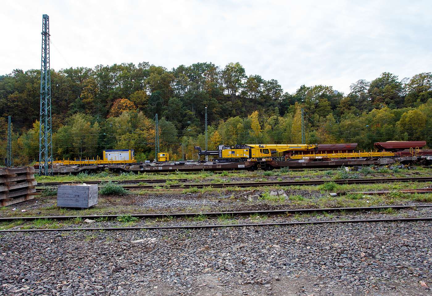 Der 150 t Gleis- und Eisenbahndrehkran (EDK) KIROW Multi Tasker KRC 1200, D-HGUI 99 80 9419 041-5 „IDEFIX“ der HERING Bahnbau GmbH in Burbach-Holzhausen, ist am 19 Oktober 2025 im Rbf Betzdorf/Sieg abgestellt. Leider stehen noch auf den Gleisen davor andere Wagen. Nach der Gewichtsklasse hätte der Kran eher den Namen „Obelix“ verdient und nicht den Namen nach Hund von Obelix „Idefix“. 

Rechts vor dem Kran ein vierachsiger Drehgestell-Flachwagen, Nummer unbekannt, der Gattung Res als Kran-Schutzwagen auslegerseitig beladen mit langen Traversen. 

Links hinter dem Kran den vierachsige Gegenlastwagen D-HGUI 99 80 9310 032-4 auf der einen Seite mit dem abgelegten Gegengewicht des Krans und auf der anderen Seite stützt, sich hier in der Transportstellung, das Gegengewicht-Teleskop hydraulisch auf dem Gegenlastwagen ab. Durch die Abstützung wird die Achslast und folglich die Streckenlast (Meterlast) vom Kran auf max. 7,2 t/m reduziert. Die max. Achslasten betragen beim Kran 13,7 t und den Wagen 19,9 t, so kann der Kranzug auf der Streckenklasse C befördert werden. 

Dahinter noch ein vierachsiger Drehgestell-Flachwagen, Nummer unbekannt, der Gattung Res als Kran-Schutzwagen gegenlastseitig, u. a, beladen mit Werkstattcontainer, kleine Traversen, Anschlagmittel und sonstiges Zubehör/Equipment.