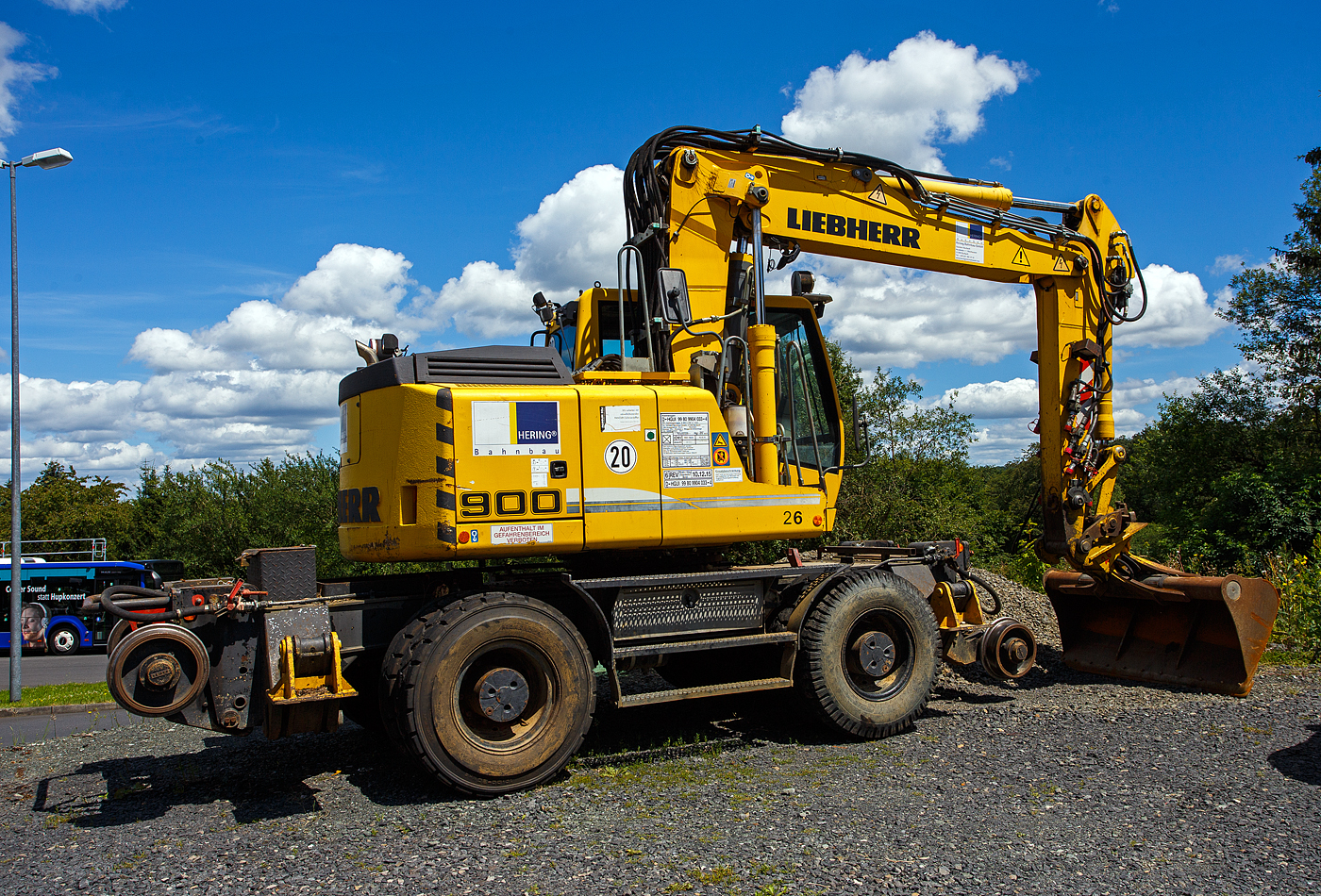 Der Liebherr A 900 C ZW Li / 1031 Zweiwegebagger mit Vier-Punkt-Abstützung, (Nr. 26) der Hering Bau GmbH und Co. KG aus Burbach-Holzhausen, Kleinwagen-Nr. D-HGUI 99 80 9904 033-4), abgestellt am 07 Juli 2024 auf dem Betriebshof der Westerwaldbahn (WEBA) auf der Bindweide bei Steinebach/Sieg. Der Zweiwegebagger hat ein Eigengewicht von 22,5 t, eine Anhängelast von 120 t und eine Höchstgeschwindigkeit von 20 km/h (in Weichen und Kreuzungen beschränkt auf 10 km/h), er hat eine Kfz -Bremse und eine Waggonbremsanlage.