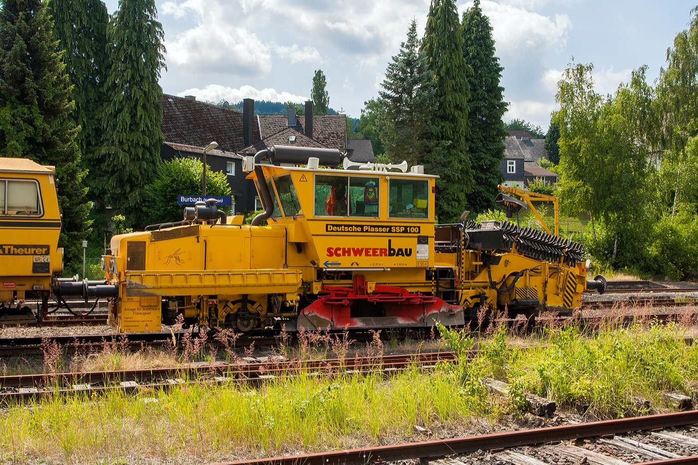 Die Deutsche Plasser Schotterverteil- und Planiermaschine SSP 100 (Schweres Nebenfahrzeug Nr. 97 16 37 539 17-4) und dahinter die Plasser & Theurer Universalstopfmaschine 08 - 475 Unimat 4S (Schweres Nebenfahrzeug Nr. 97 43 42 528 17-7) beide von der Schweerbau sind am 15 Juli 2013 im Bahnhof Burbach/Siegerland abgestellt.

Der Schotterpflug wurde 1994 unter der Masch.-Nr. 531 bei der Deutschen Plasser gebaut.