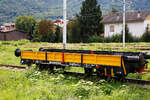 Ein italienischer 2-achsiger Gleiskraftwagenanhnger (W D CRR MI 0098 L) abgestellt  am 14.09.2017 beim Bahnhof Tirano (aufgenommen aus einem Zug heraus).